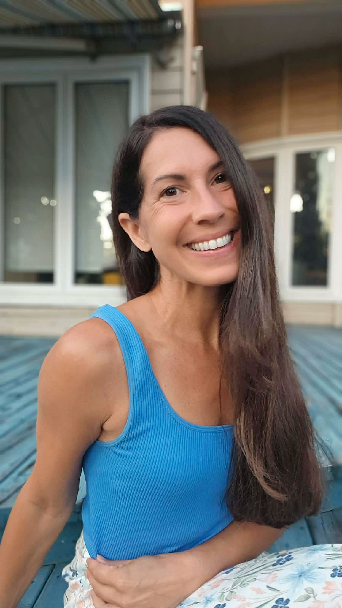 Émilie sourit à la caméra, en camisole bleue